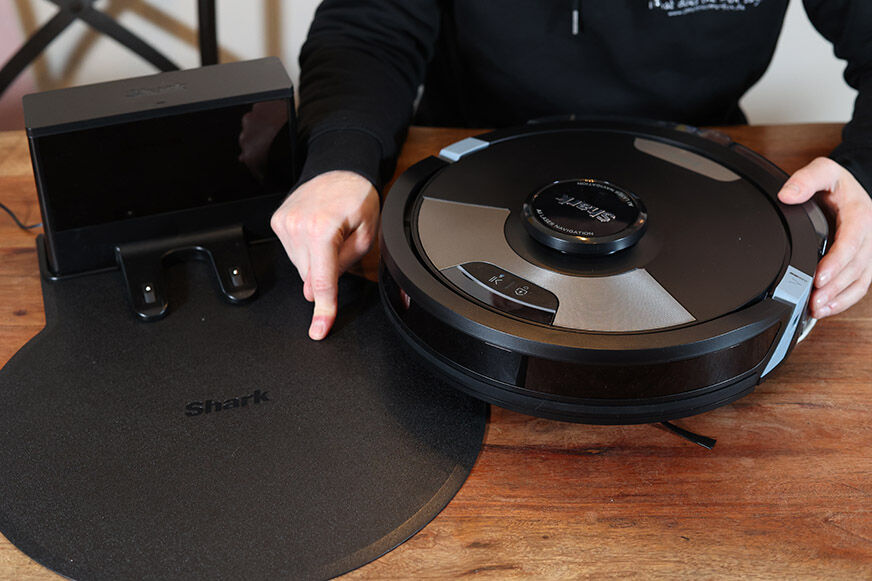 Eine einfache Ladestation eines Shark Saugroboters steht auf dem Boden.